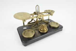 Sampson Mordan & Co., London, brass postal scales, with weights, on an ebonised mahogany base,