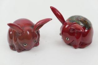 Two Bernard Moore flambe rabbits, grazing, both with original glass eyes, one having a mottle glazed