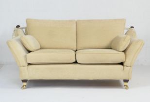 Multiyork knole settee, upholstered throughout in pale gold fabric, with brass castors, width 195cm,