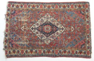 Heriz woollen rug, having a central blue and fawn reserve with a red field dispersed with