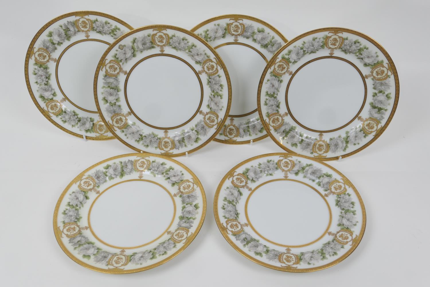 Six Haviland Limoges gilded dessert plates, the borders decorated with roses in pinks and tooled