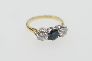 Diamond and sapphire three stone ring, the central round cut sapphire of approx. 0.75ct, flanked