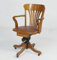 George V oak swivel office chair, bowed back with open arms and rexine pad seat, over swivel