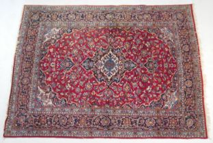 Iranian Kirman style woollen carpet, central fawn and dark blue medallion within a red field