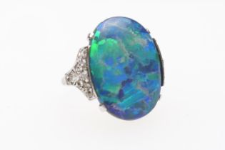 Black opal and diamond ring, having a cabochon opal doublet of approx. 20mm x 16mm, the shoulders
