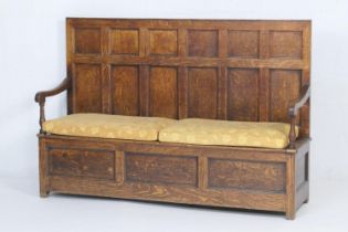 Oak panelled box settle, early 19th Century, the seat with two lift up panels over a three