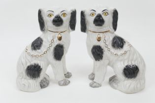 Pair of Victorian Staffordshire spaniels, finished in black and white with gilt chain and padlock,