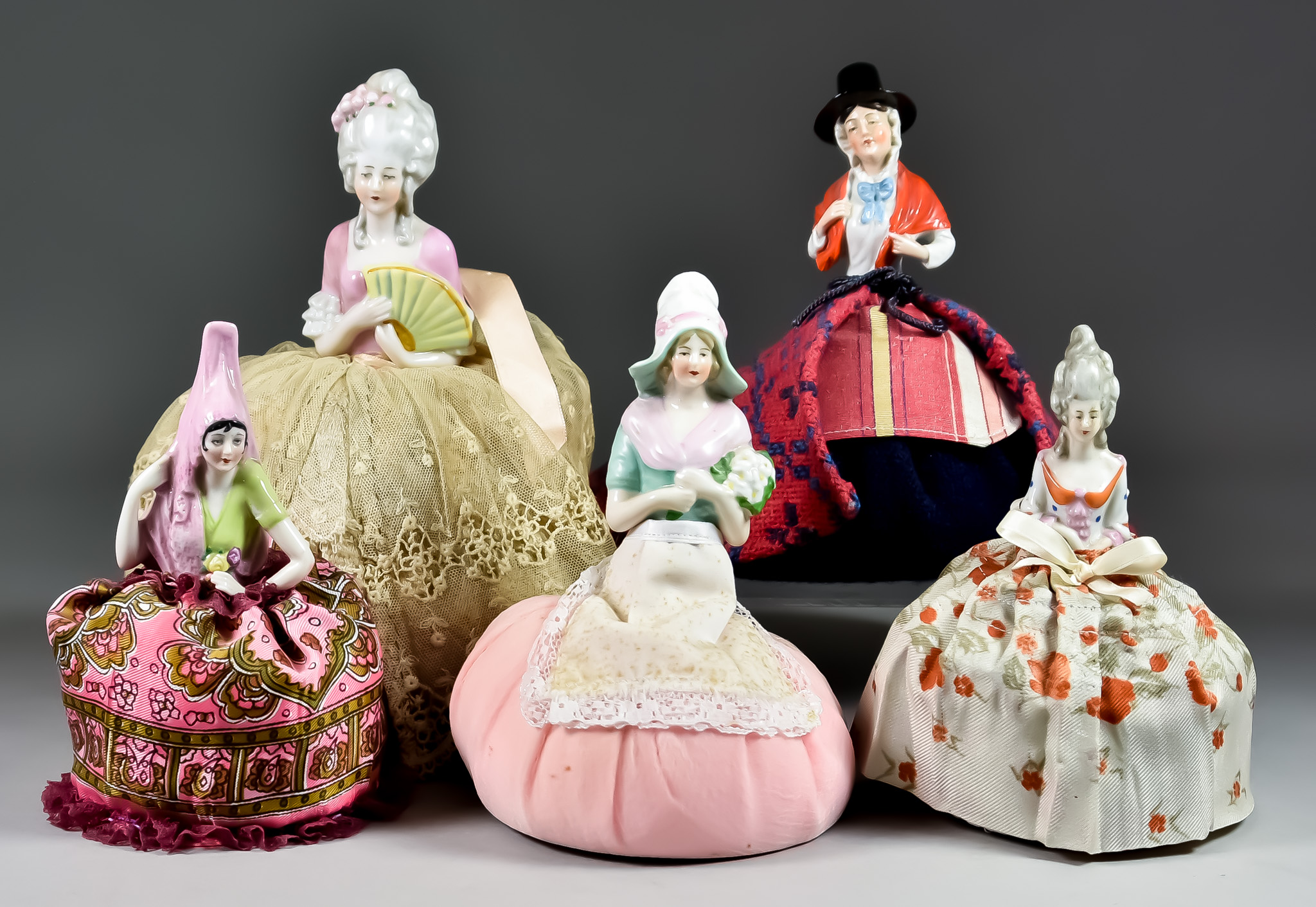 Fifteen Early 20th Century Porcelain Pincushion Half-Dolls with Fabric Skirts, including a Welsh