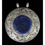 An Arabic Pendant, 20th Century, silvery metal, set with a centre Lapis Lazuli panel, 25mm in