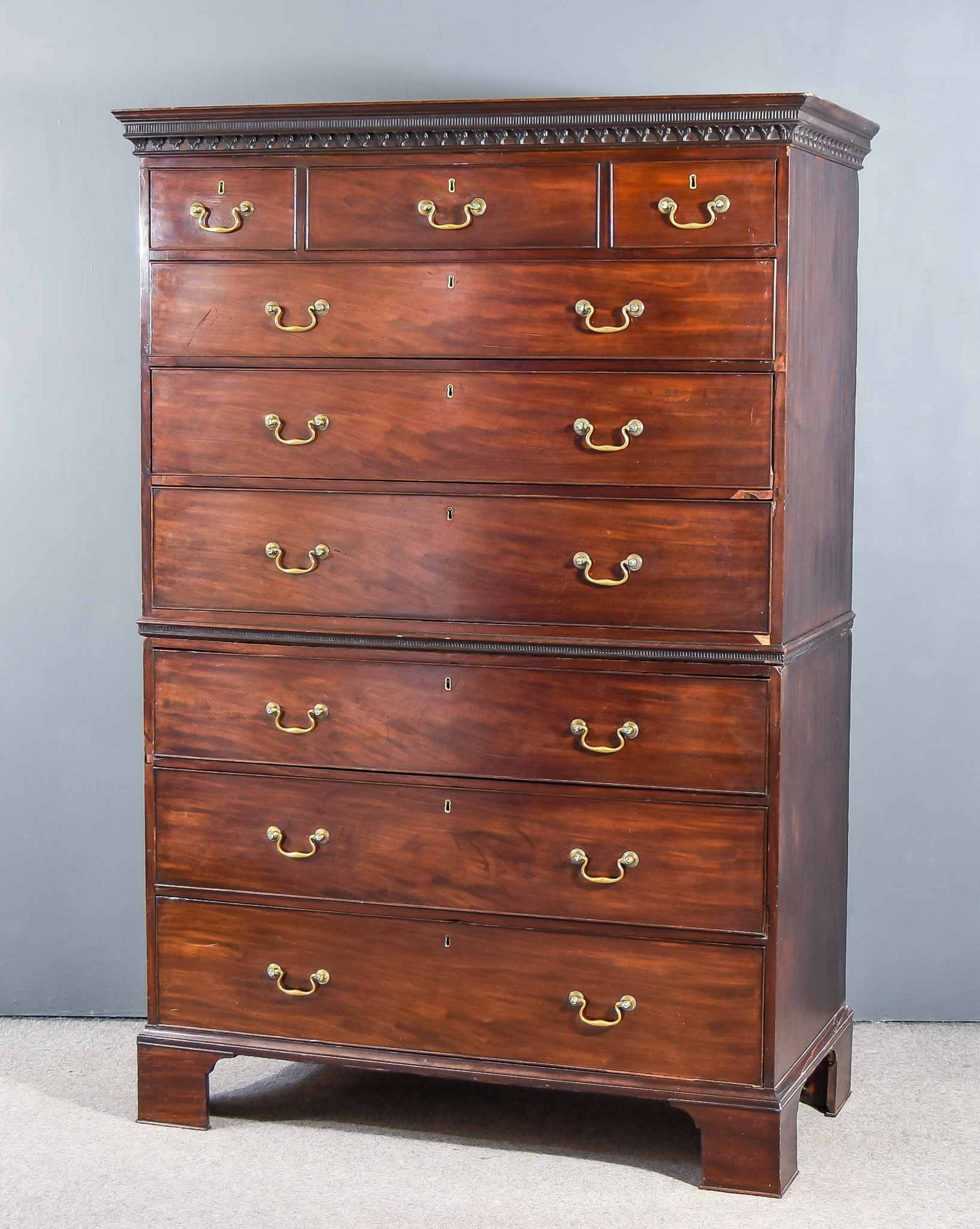 A George III Mahogany Tallboy, the upper part with moulded cornice and dentil frieze, the top fitted
