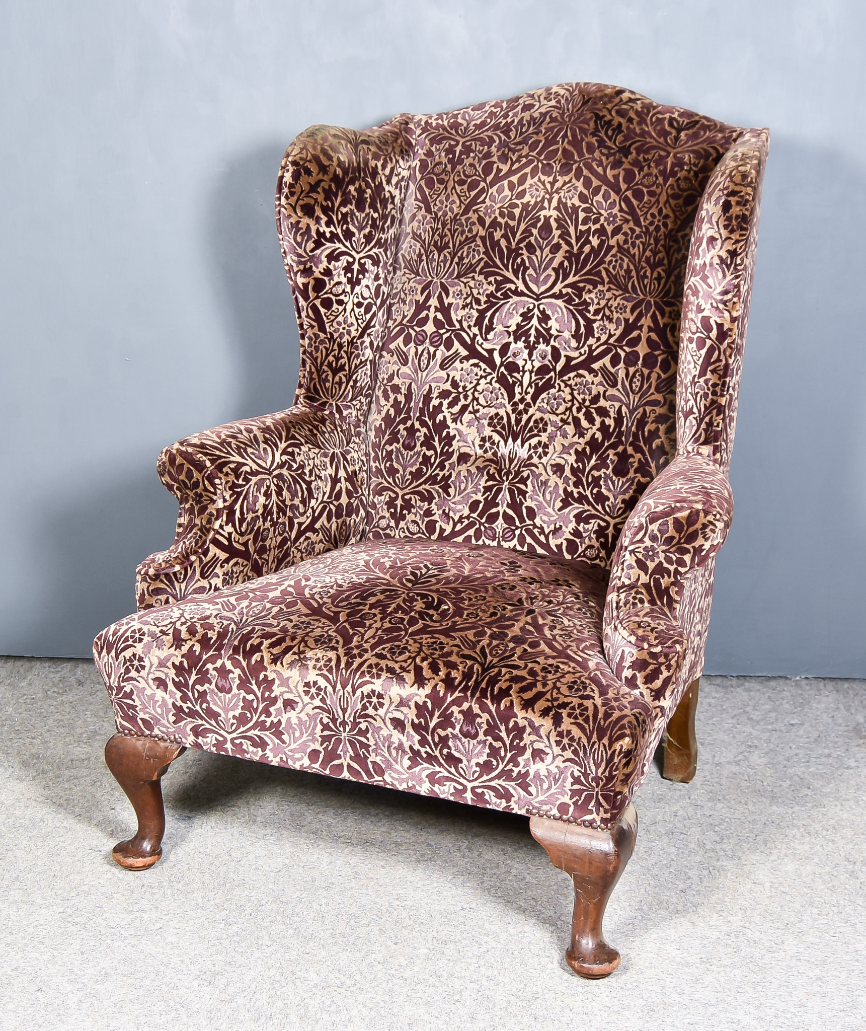 A 20th Century Wingback Easy Chair of Georgian Design, upholstered in mauve and beige patterned