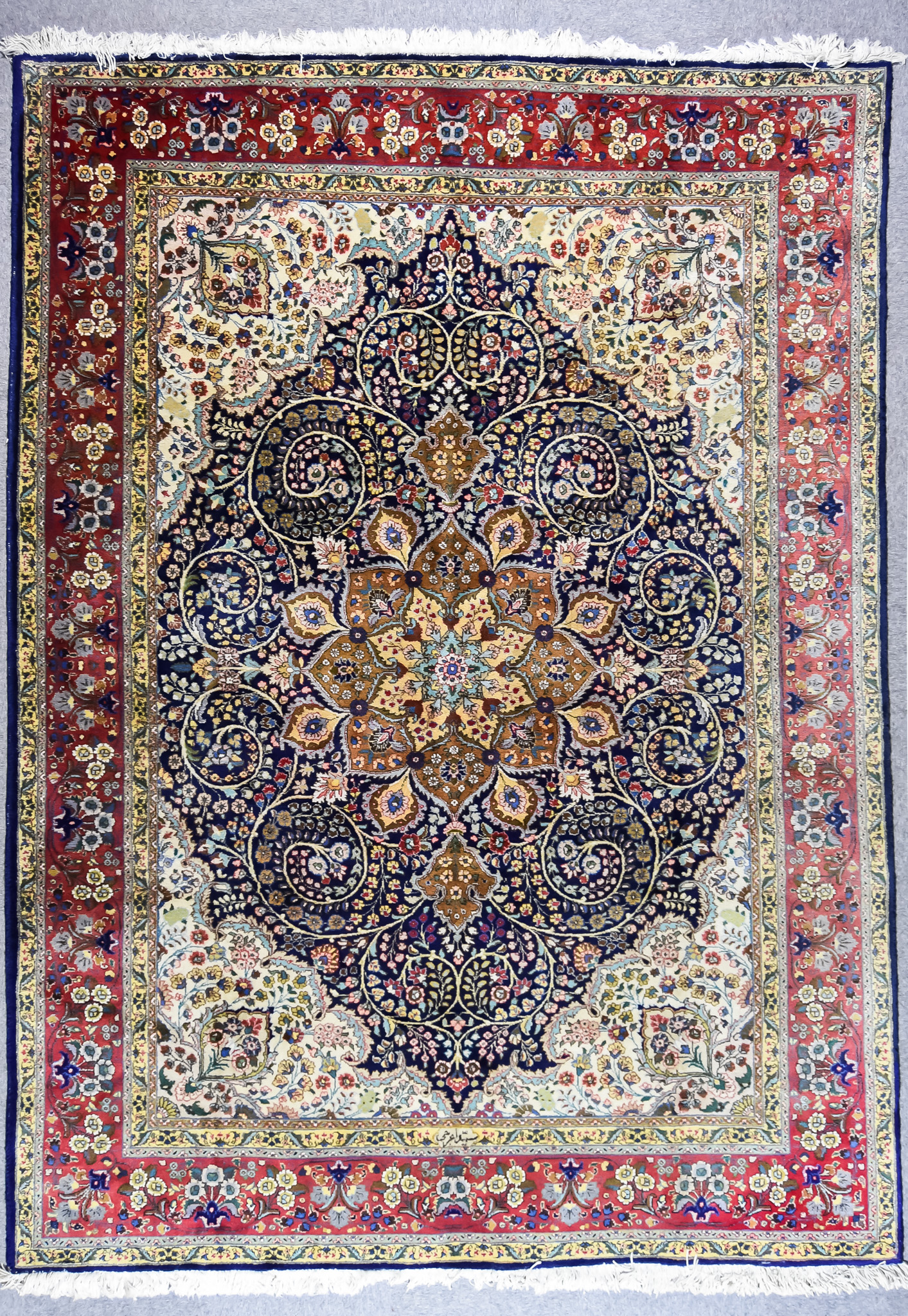 An Early 20th Century Tabriz Carpet, woven in colours of ivory, navy blue and green, with a bold