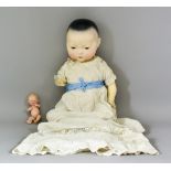 A Bisque-Headed Oriental Baby Doll, Late 19th/Early 20th Century, with brown open/shut eyes,