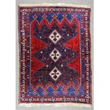 A 20th Century Afshar Rug, woven in colours of ivory, navy blue and wine, with three lozenge