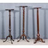 Three Mahogany Circular Torcheres, of various designs, all 12ins diameter x 44ins to 48ins high