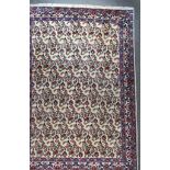 An Early 20th Century Qum Carpet, woven in colours of ivory, navy blue and wine, the field filled