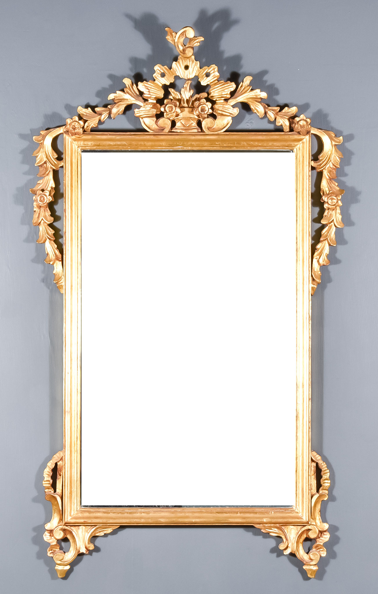 An Early 20th Century Gilt Framed Rectangular Wall Mirror, carved shaped cresting, with trailing