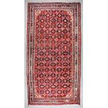 A 20th Century Mehraban Carpet, woven in colours of ivory, navy blue and wine, the field filled with