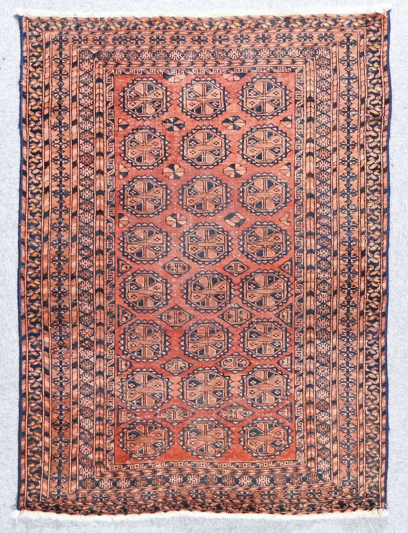 A Late 19th/Early 20th Century Turkmen Rug, woven in colours of fawn, terracotta and navy blue, with