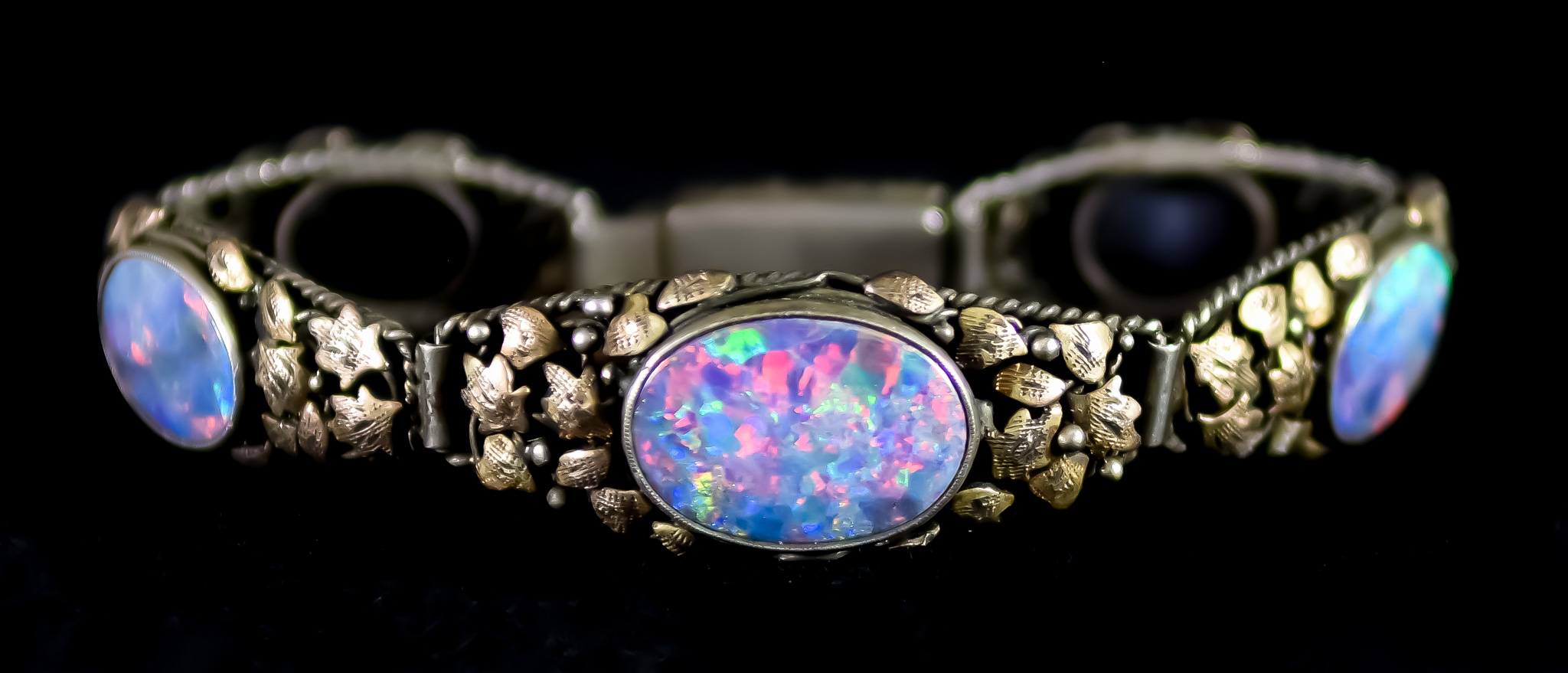 A Five Stone Fire Opal Bracelet, 20th Century, silver base with 9ct gold leaves to the front set