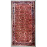 A 20th Century Malayer Carpet, woven in colours of ivory, navy blue and wine, the field filled