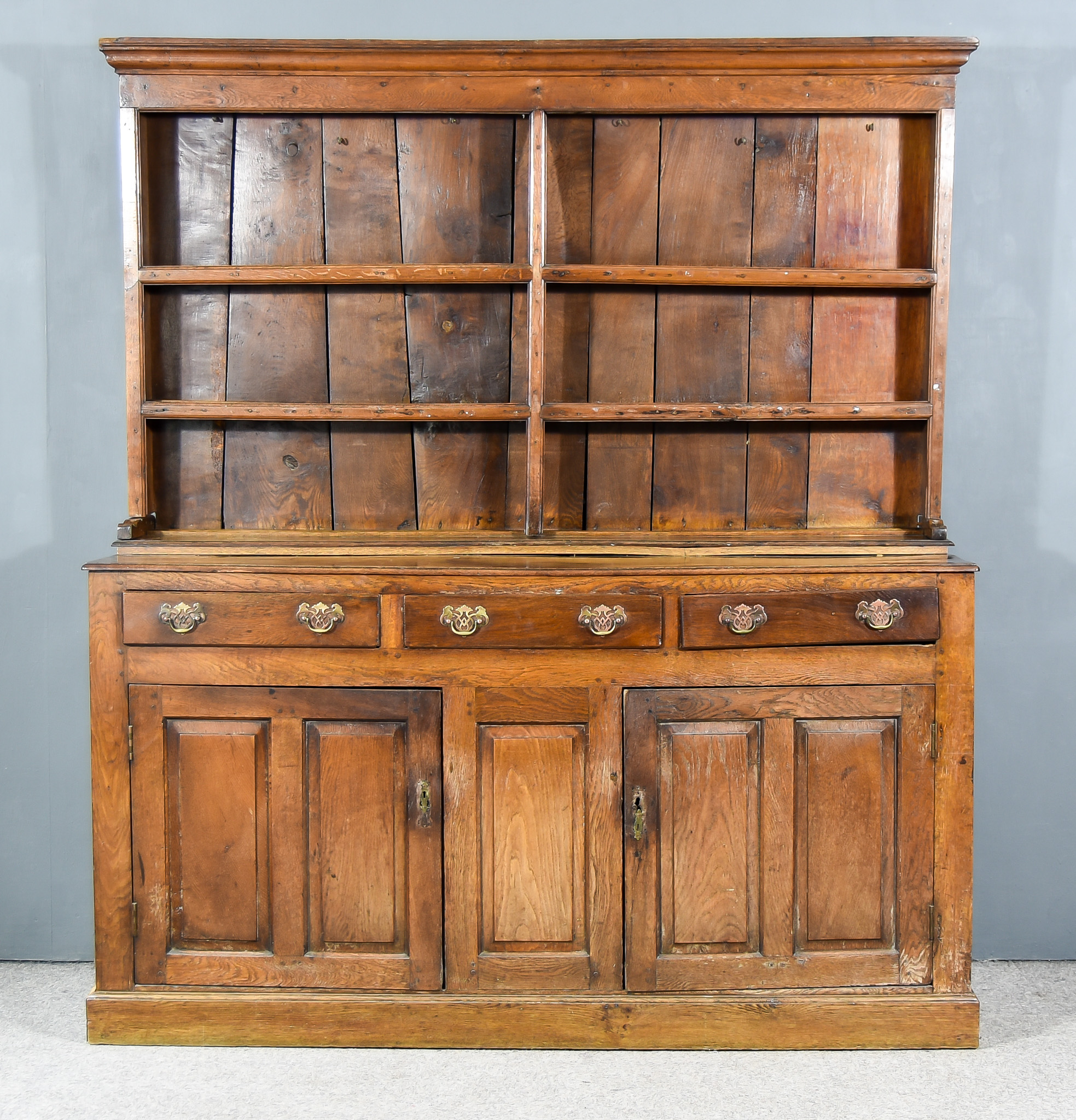 A Late 18th Century Panelled Oak Dresser, the upper part with moulded cornice, fitted three open