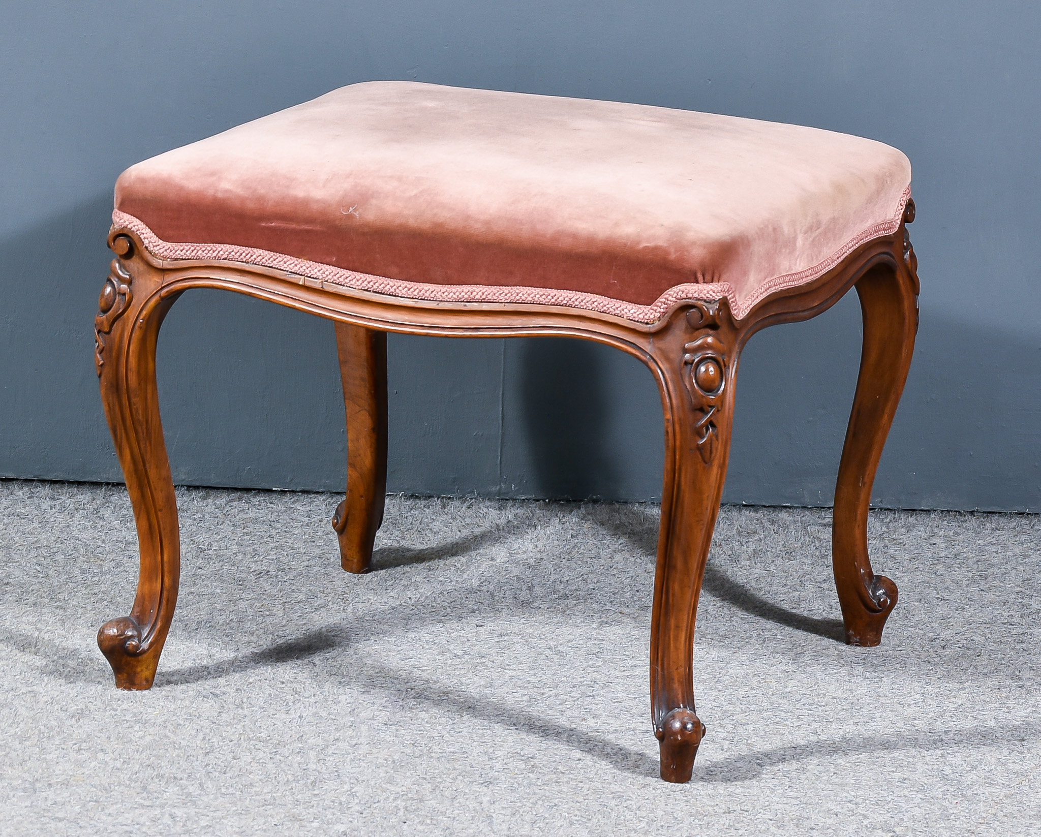 A Victorian Walnut Stool, upholstered in rose dralon, on carved and moulded cabriole legs with