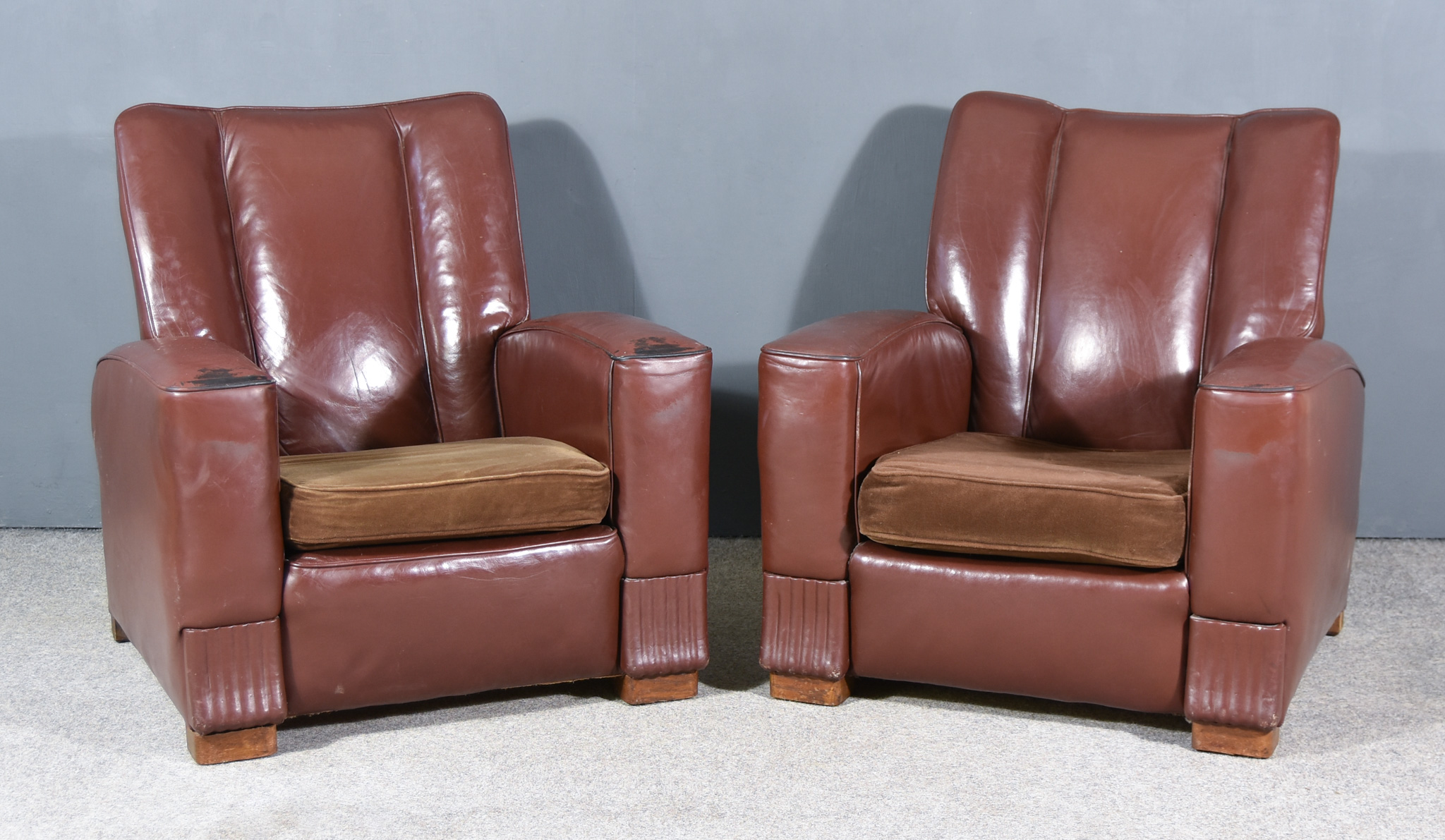 A Pair of Early 20th Century Square Back Easy Chairs of Art Deco Design, upholstered in brown