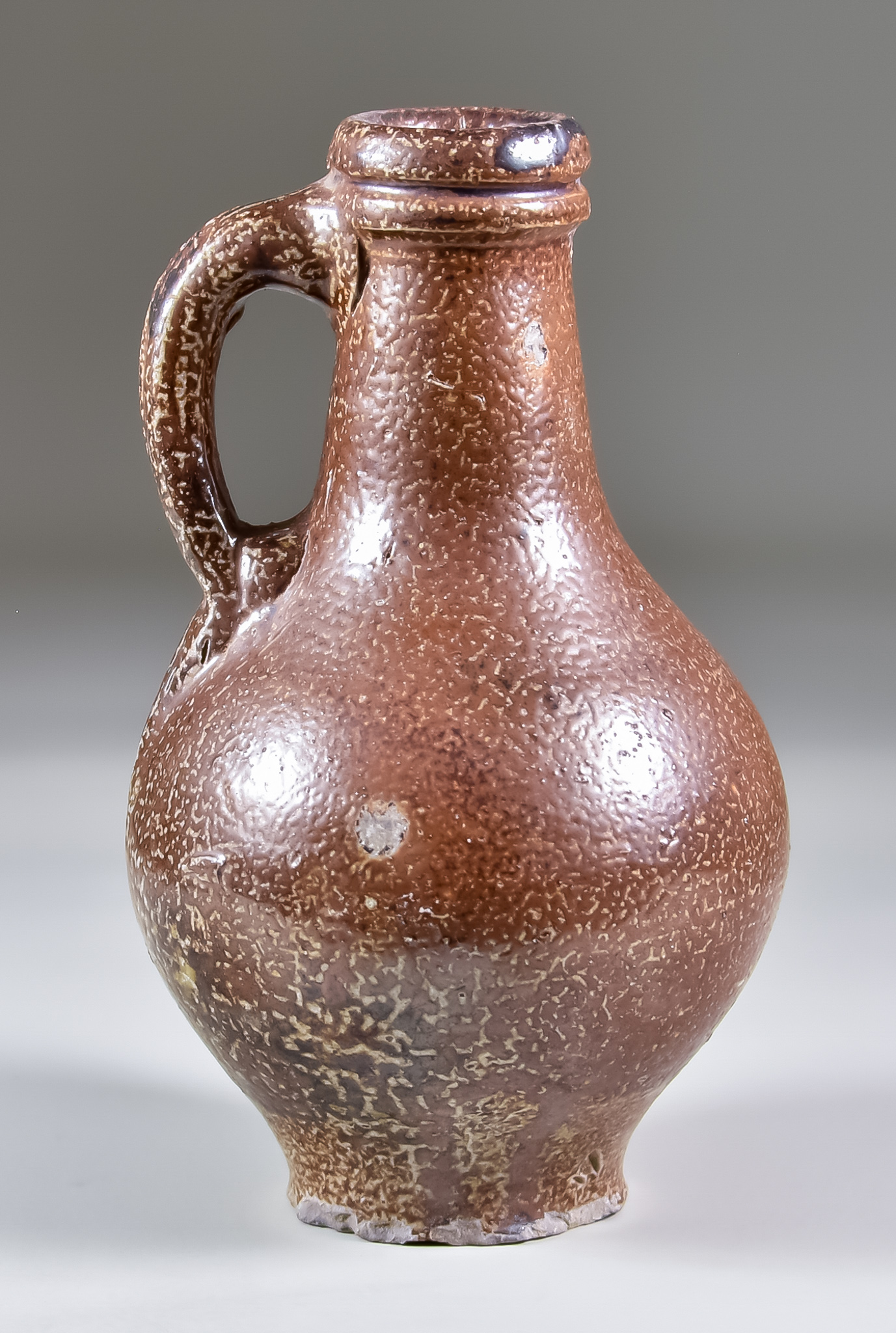 A 17th Century German Salt Glaze Stoneware Bartmann Krug of Small Proportions, 7ins high