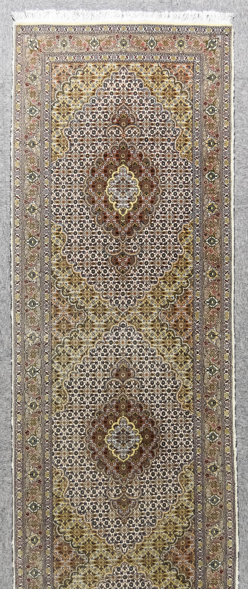 A 20th Century Tabriz Runner, woven in colours of fawn, ivory and rose, with three lozenge shaped