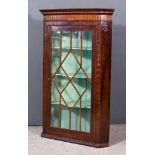 A George III Mahogany Hanging Corner Cupboard, with moulded cornice, frieze inlaid and with shell