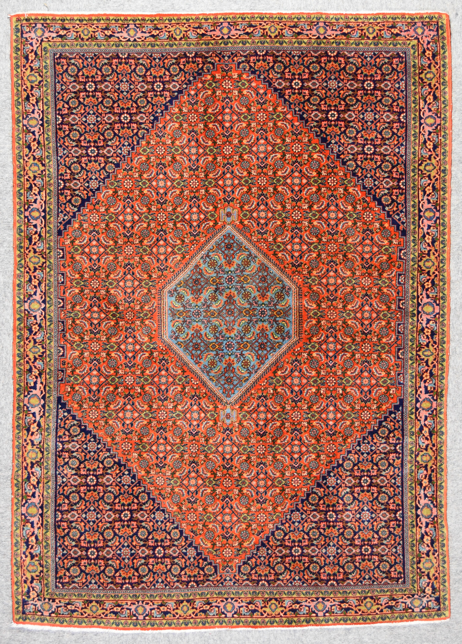 An Antique Bidjar Rug, woven in colours of ivory,navy blue and wine, with a central hexagonal gul,