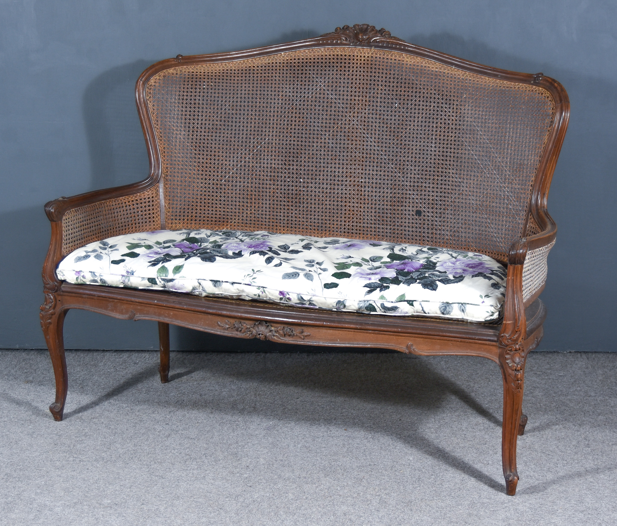 A Late 19th Century Walnut Framed Settee of Louis XV Design, the shaped and moulded back with floral