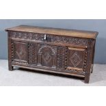 A 17th Century Panelled Oak Coffer with moulded edge to two plank top, frieze carved with interlaced