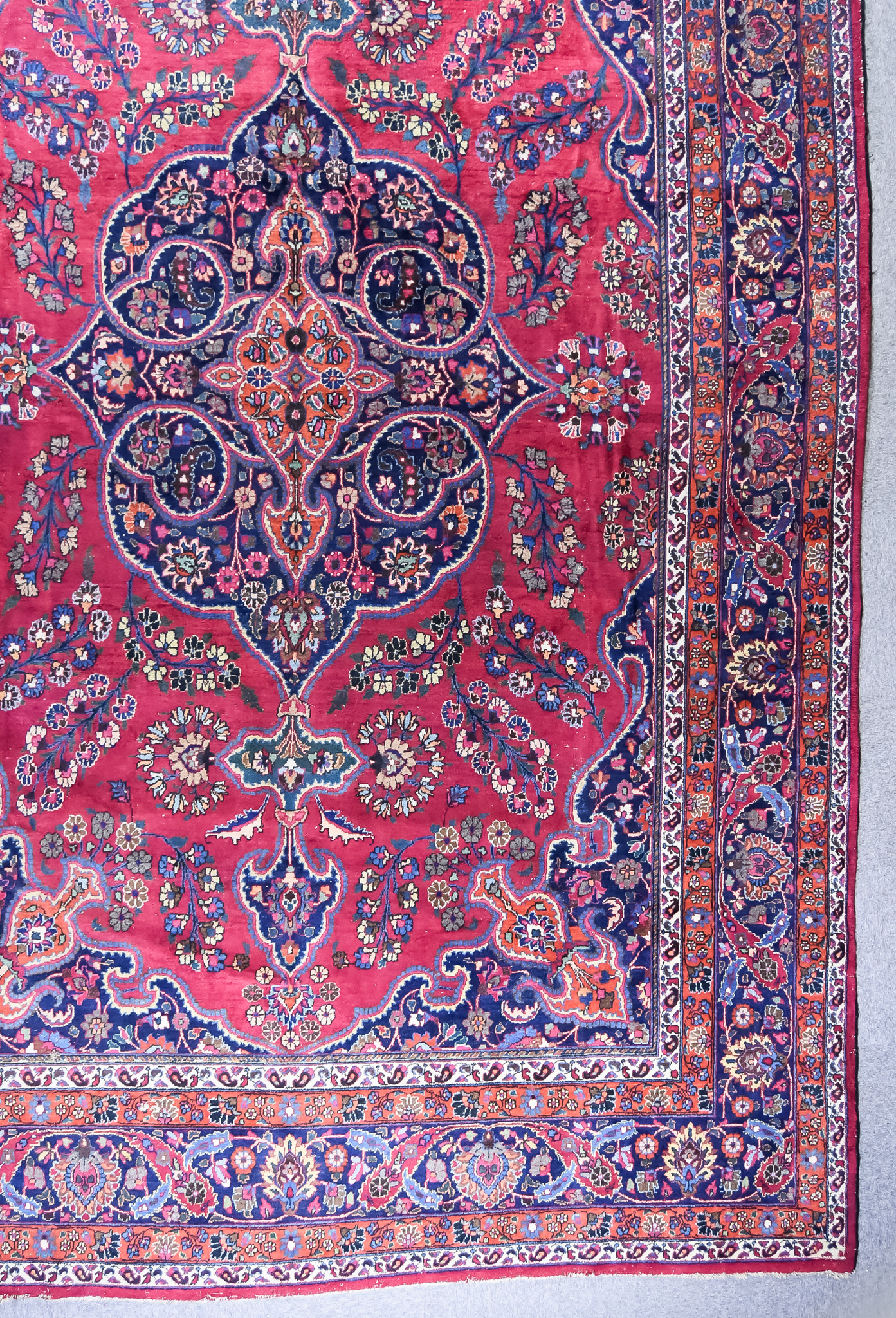 An Antique Khorassan Carpet, woven in colours of burnt orange, ivory, navy blue and madder with a
