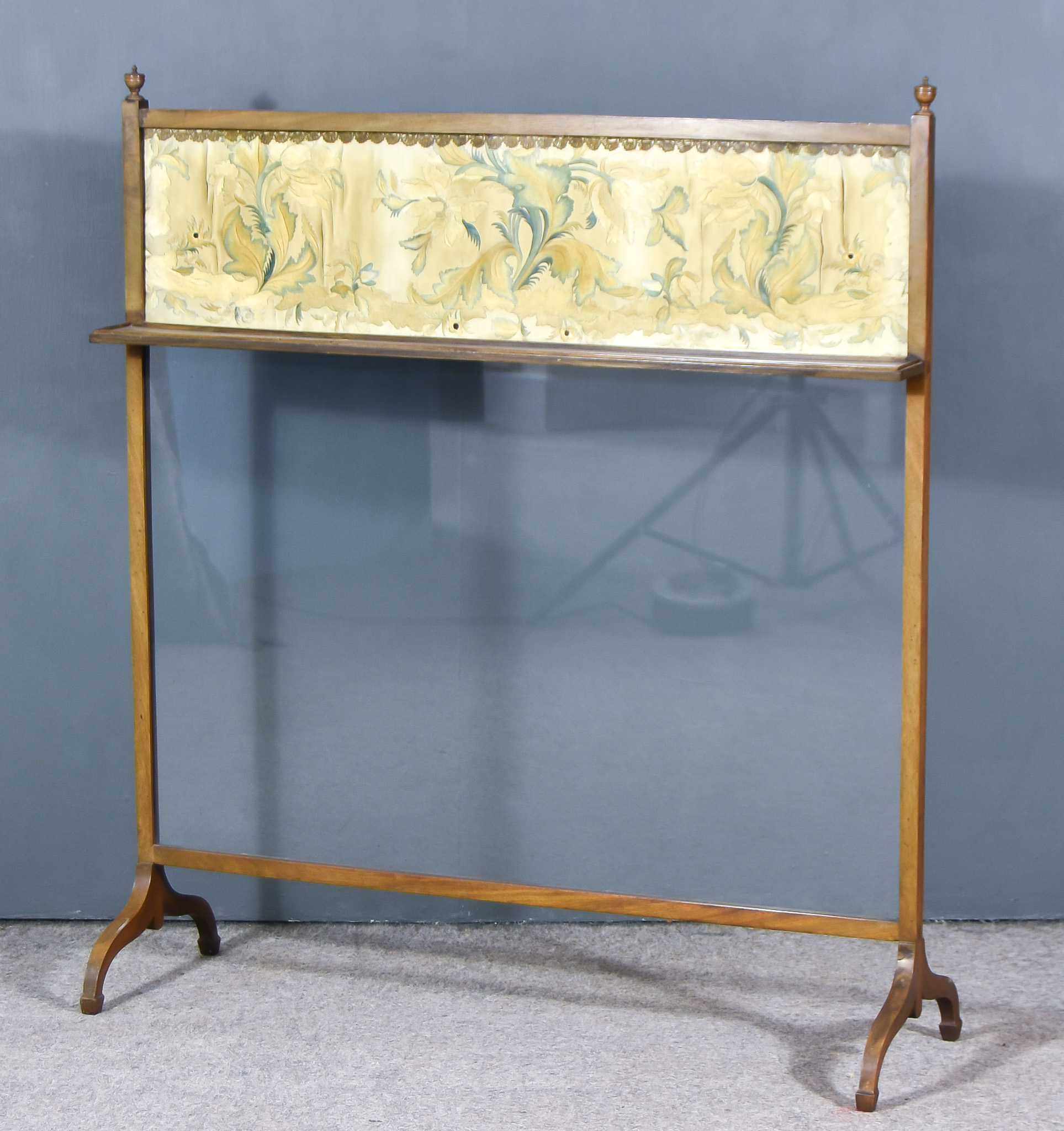 A Mahogany Framed Fire Screen, with turned finials, inset with silk and glazed panels, on shaped