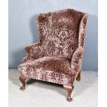 A 20th Century Wingback Easy Chair of Georgian Design, upholstered in mauve and beige patterned