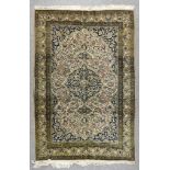 A 20th Century Part Silk Qum Rug, woven in pastel shades, with a bold stylized floral medallion,