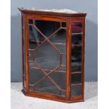 An Edwardian Mahogany Hanging Corner Cupboard, with moulded dentil cornice, fitted two shelves