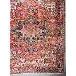 An Antique Heriz Carpet, woven in colours of ivory,navy blue and wine, with a bold central cross