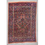 An Antique Bidjar Rug, woven in colours of ivory, navy blue and wine, with a bold central floral