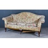 An Early 20th Century Camel Back Settee, with outscrolled arms, floral loose covers, on mahogany