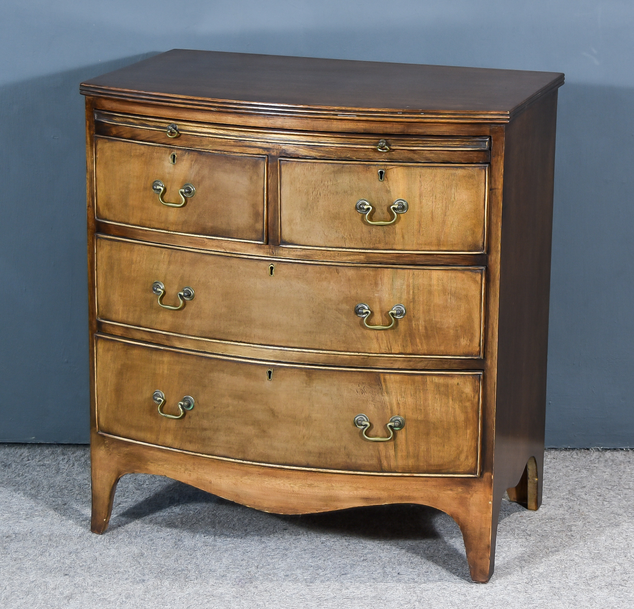 A Mahogany Bow Front Chest of George III Design, with reeded edge to top, fitted brushing slide, two