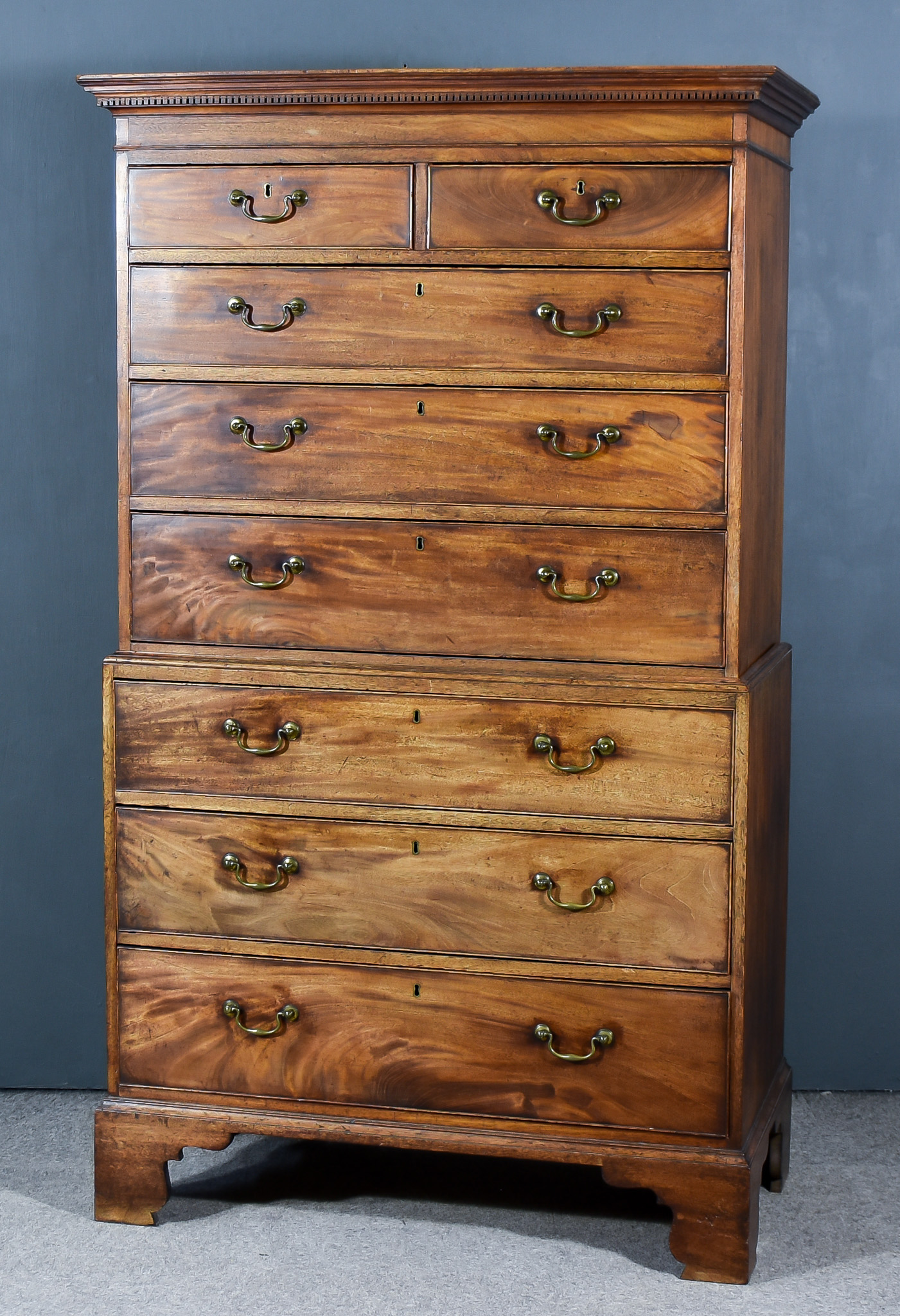 A George III Mahogany Tallboy the upper part with moulded dentil cornice, fitted two short and three