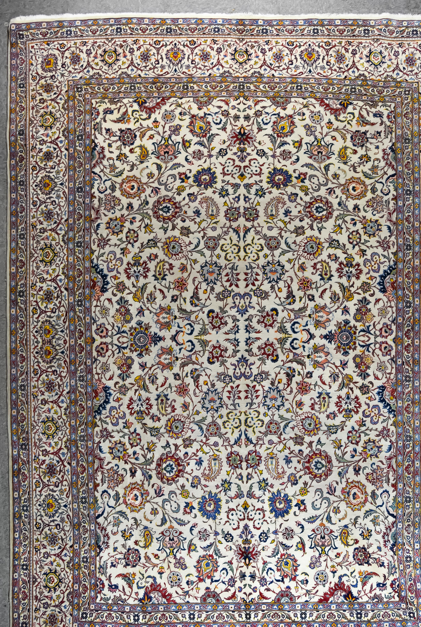 An Antique Kashan Carpet, woven in colours of ivory, navy blue and wine, the field filled with