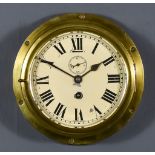 An Early 20th Century Brass Bulkhead Cased Wall Clock, the 7ins diameter painted metal dial with