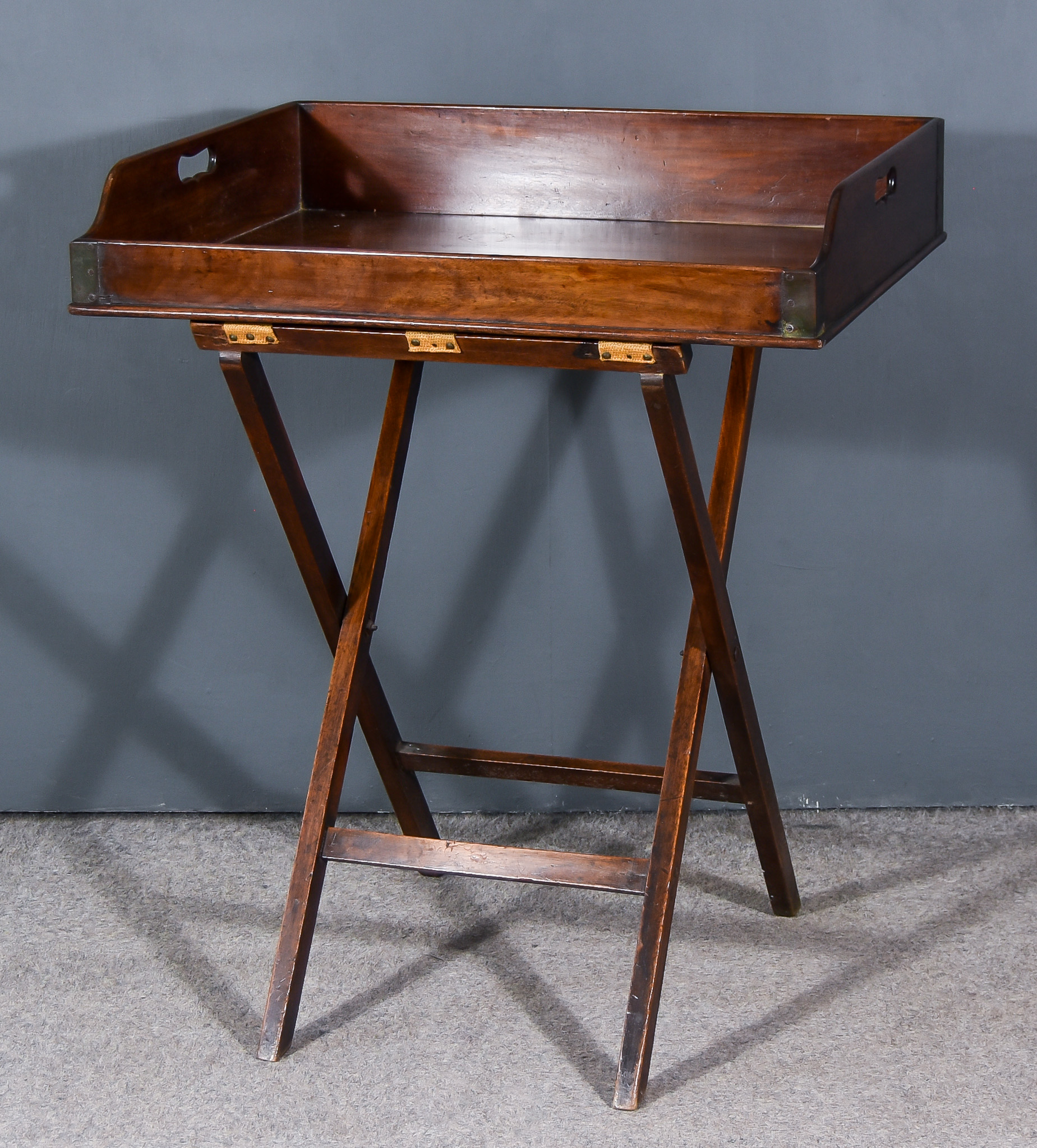 A 19th Century Mahogany Rectangular Butlers Tray, with handle cut-outs and folding stand, 30ins x