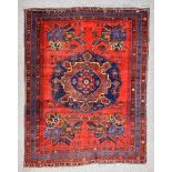 An Antique Afshar Rug, woven in colours of ivory, navy blue and wine, with a bold central floral