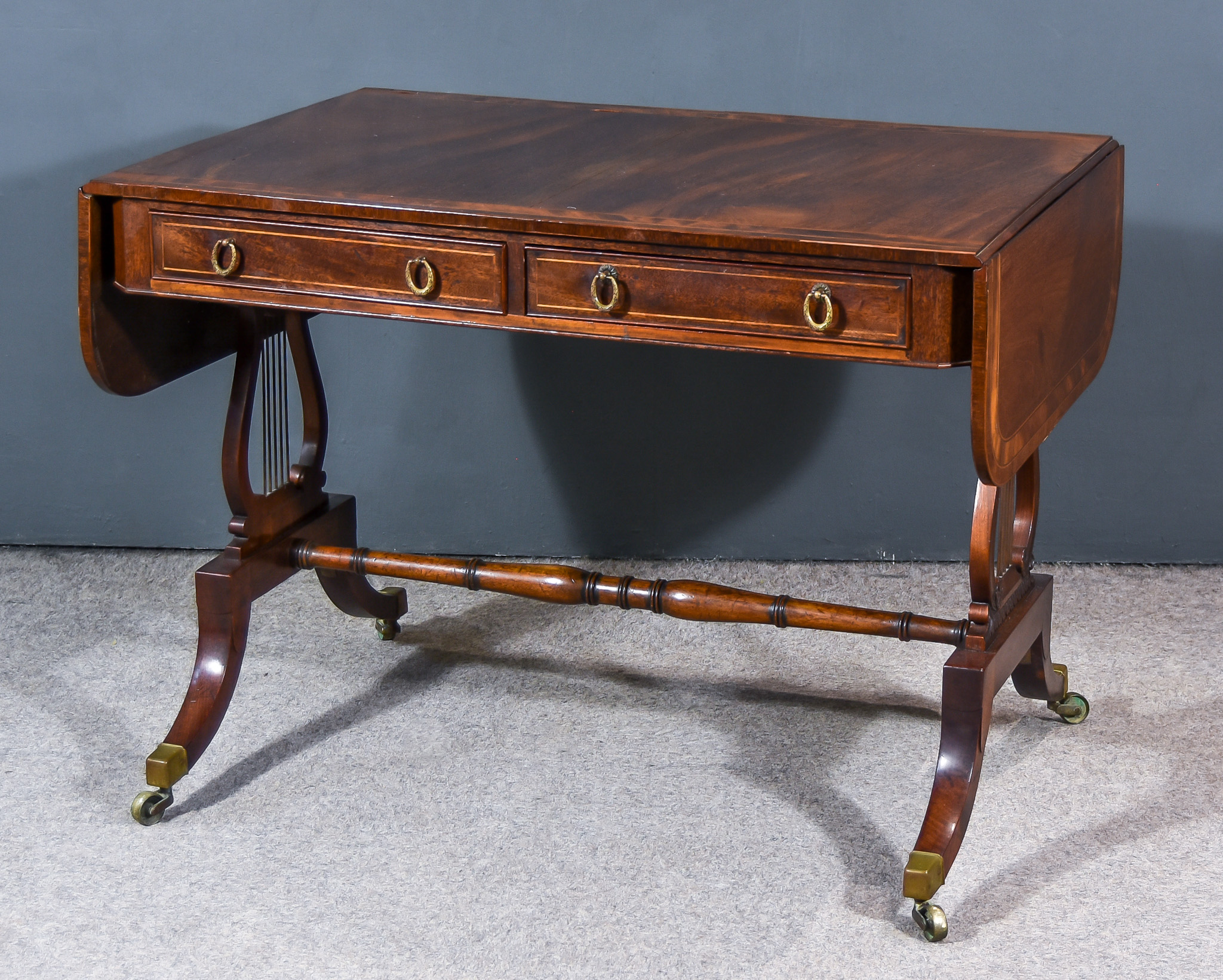 A Mahogany Sofa Table of "Georgian" Design, the top inlaid with bandings, fitted two real and two