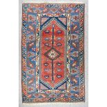 A 20th Century Afshar Rug, woven in colours of ivory, navy blue and wine, with a central hooked
